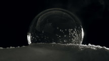 Ice ball with snow flakes freezing slow
