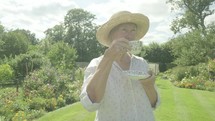 Senior caucasian woman gardening in her garden themes of retirement relaxing seniors portraits drinking