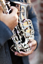 playing a silver alto saxophone man holding