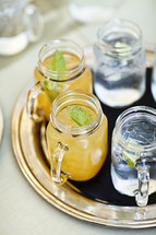 Drinks sitting on a tray lemonade and ice water mason jars