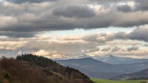 Evening clouds moving fast over snowy mountains in spring landscape Time lapse
