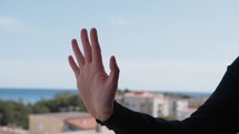 Woman's Hand Overlooking Black Greetings From Balcony