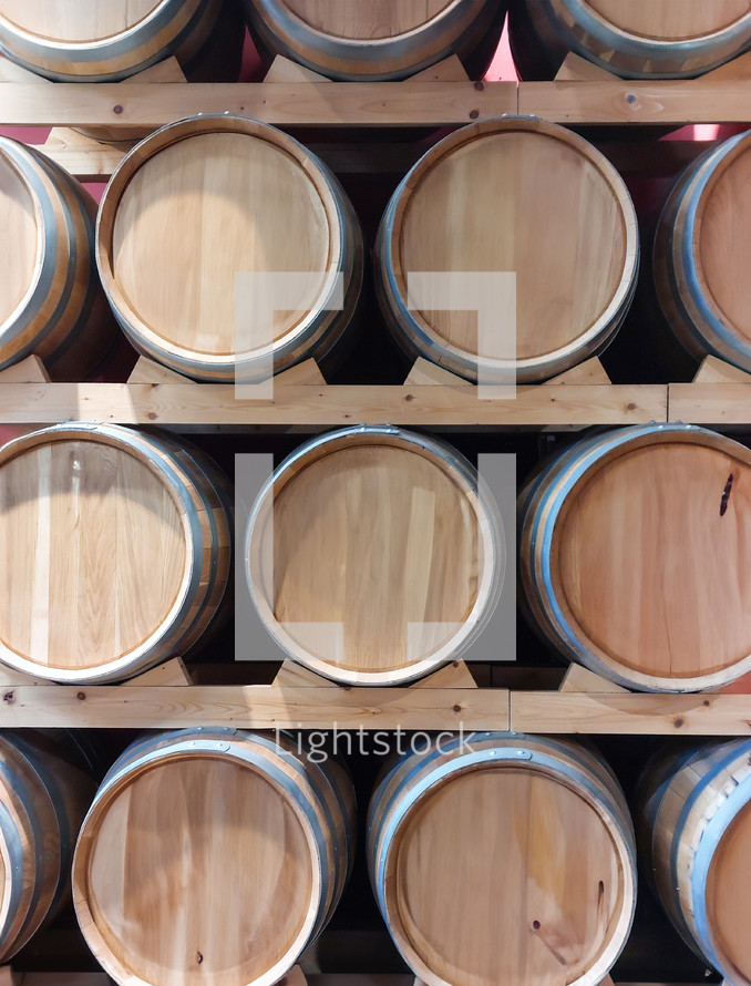 Display of oak barrels stacked on wooden shelves in a wine cellar