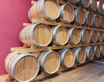 Wine barrels stacked in a pyramid shape are aging wine in a cellar