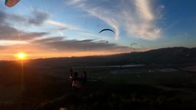 Peaceful evening paragliding flight with friends at sunset

