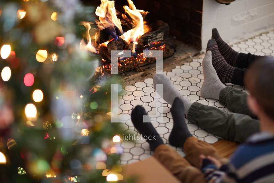 kids warming and relaxing in front of a fire at Christmas 