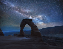 stars in the night sky over rock arch 