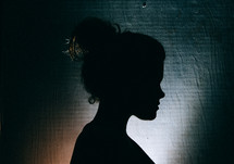 silhouette of the side profile of a woman with a hair bun 