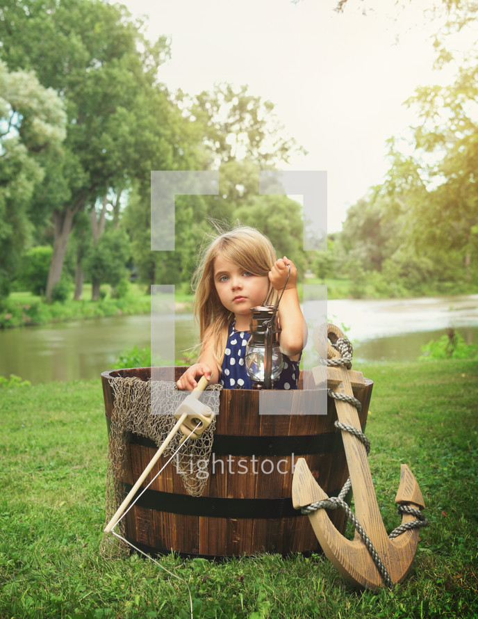 a child in a barrel pretending its a boat