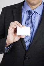 businessman holding up a blank business card 