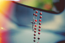 rosary hanging from a rearview mirror 