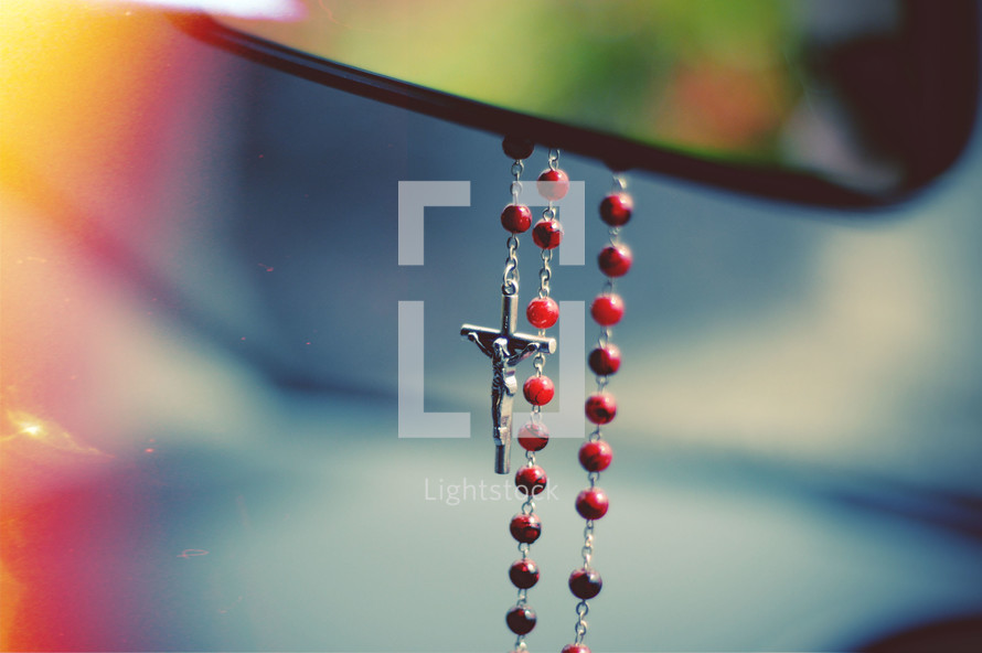rosary hanging from a rearview mirror 