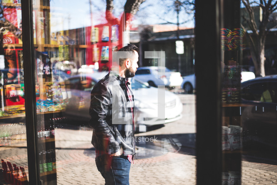 a man walking in front of a store front window 