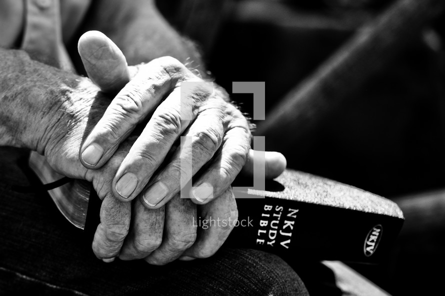 Elderly man's hands holding a Bible.