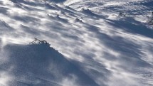 Strong wind blowing snow in frozen winter alps mountains in windy nature, wind warning outdoor background
