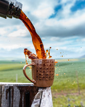 pouring coffee into a mug outdoors 