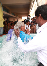 man being dunked during a baptism in India