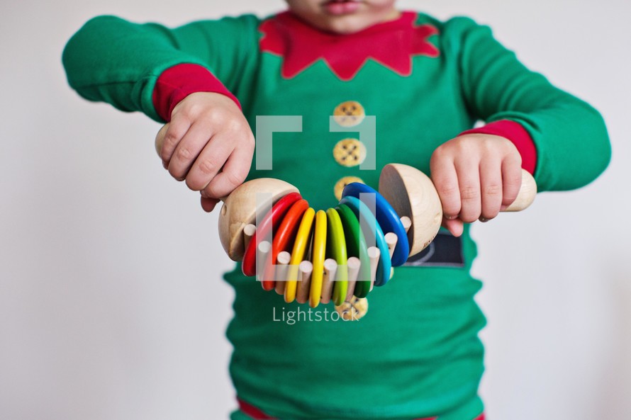 kid playing with toys in elf pajamas 