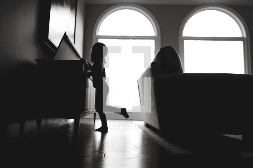 silhouette of a child in a living room 