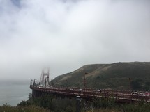 bridge along a shore in fog 