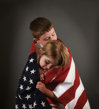 children wrapped in an American flag 