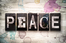 word peace on white washed wood