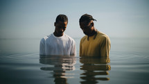 Baptism. Portrait of two black men in prayer in the water
