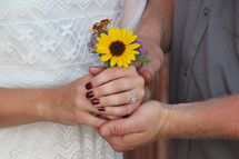 a couple holding hands and flowers 