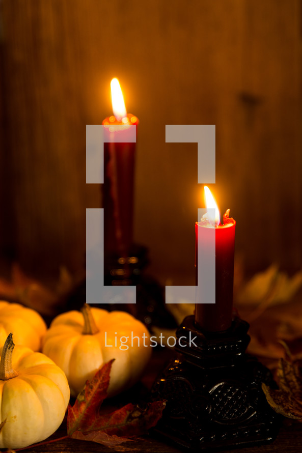 a candle with fall pumpkins