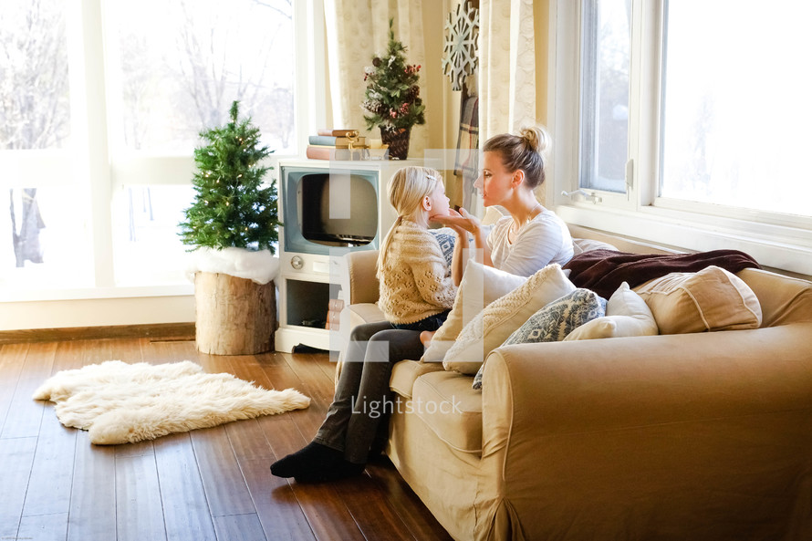 mother and daughter talking on a couch 