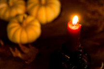 a candle with fall pumpkins