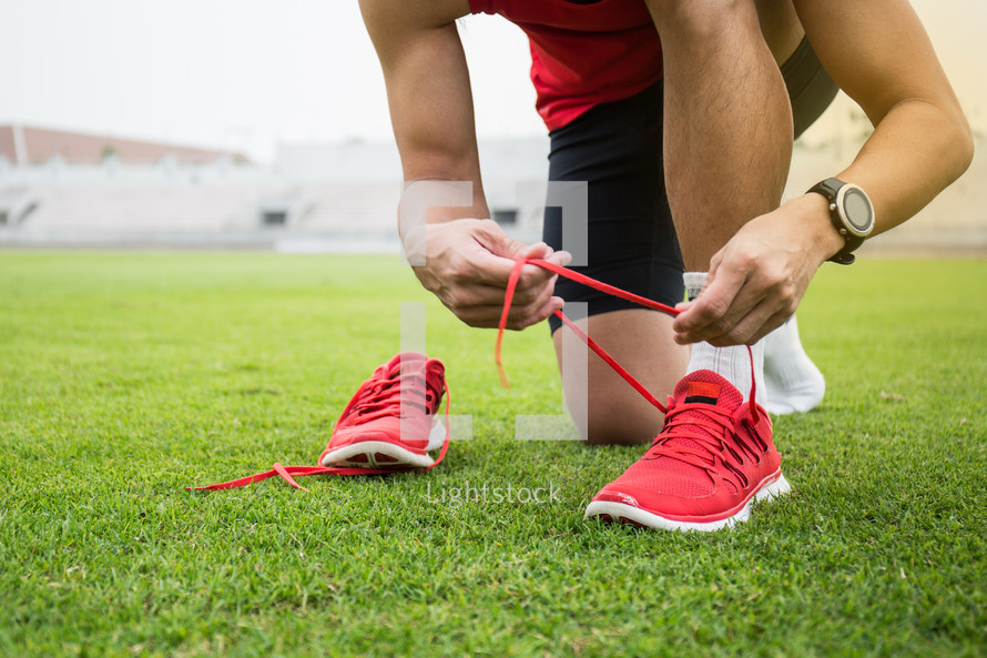 an athlete tying his shoes 