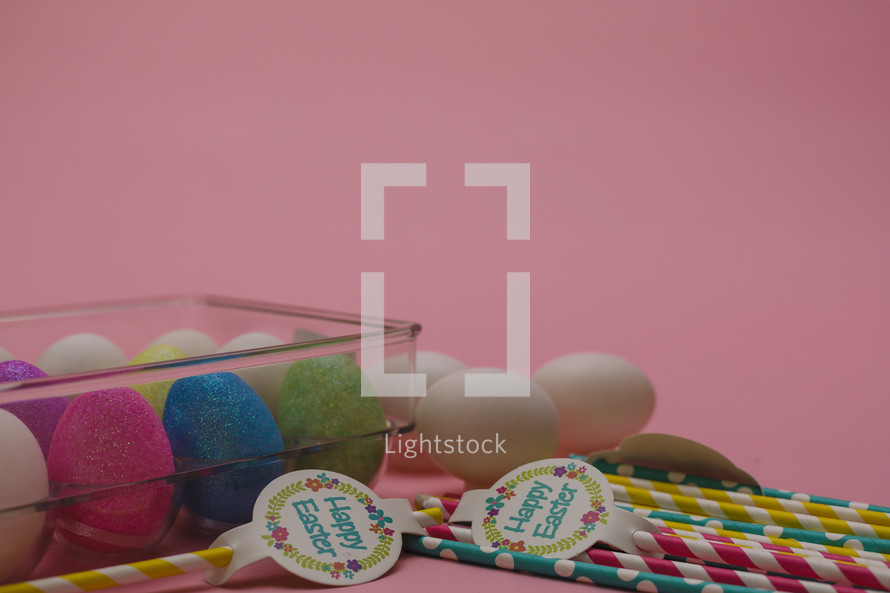 Easter eggs in a carton and paper straws 