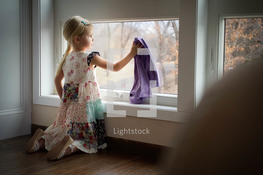 child cleaning a window 