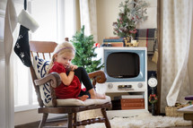 a child sitting in a chair at Christmas time 
