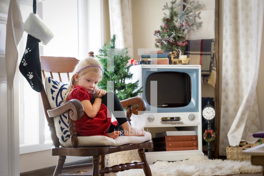 a child sitting in a chair at Christmas time 