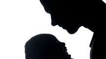 silhouette of a father cradling his newborn 