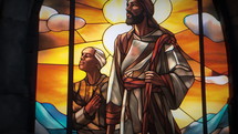 Close-up shot of a beautiful, dimly back-lit stained glass window of Nativity Shepherds with snow just starting to fall. Stained glass was generated with AI and composited into a 3D CGI scene.