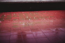Rain drops falling on red tile.