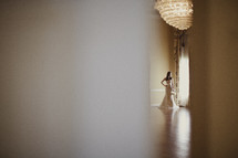 A bride standing next to the window in her wedding dress
