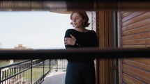 Woman Dressed In Black Cold On The Balcony At Home