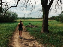 a woman walking on a dirt trail 