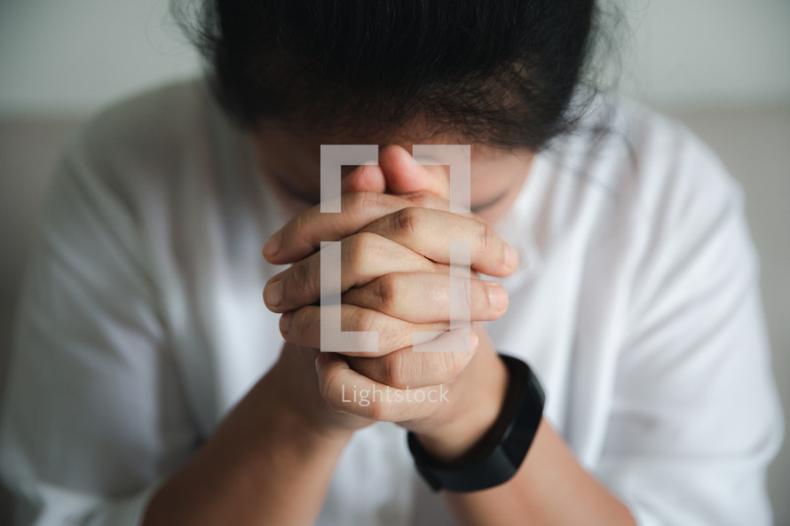 Woman with clasped hands praying