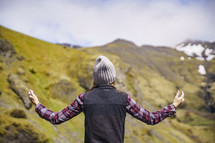 a woman with arms raised standing outdoors in Iceland 