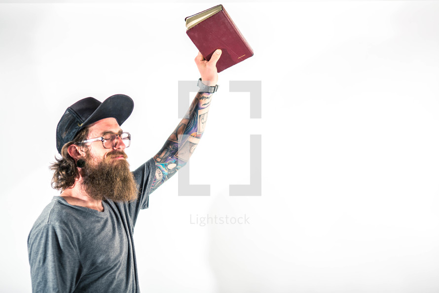 man holding a Bible up praising God 