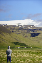 a woman looking out at a green landscape in Iceland 