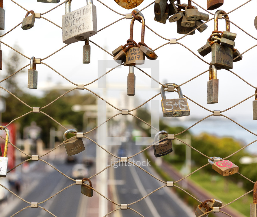 love locks on a fence overlooking a highway 