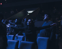 woman with outstretched arms during a worship service 