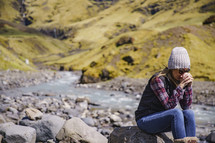 a woman sitting outdoors praying in Iceland 