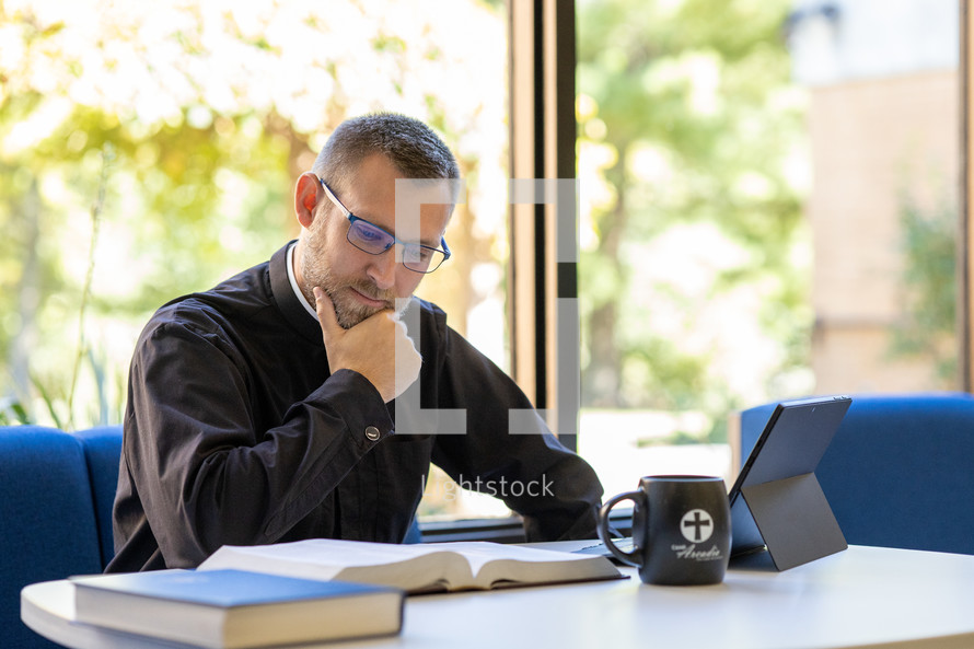 Pastor studying in front of a window